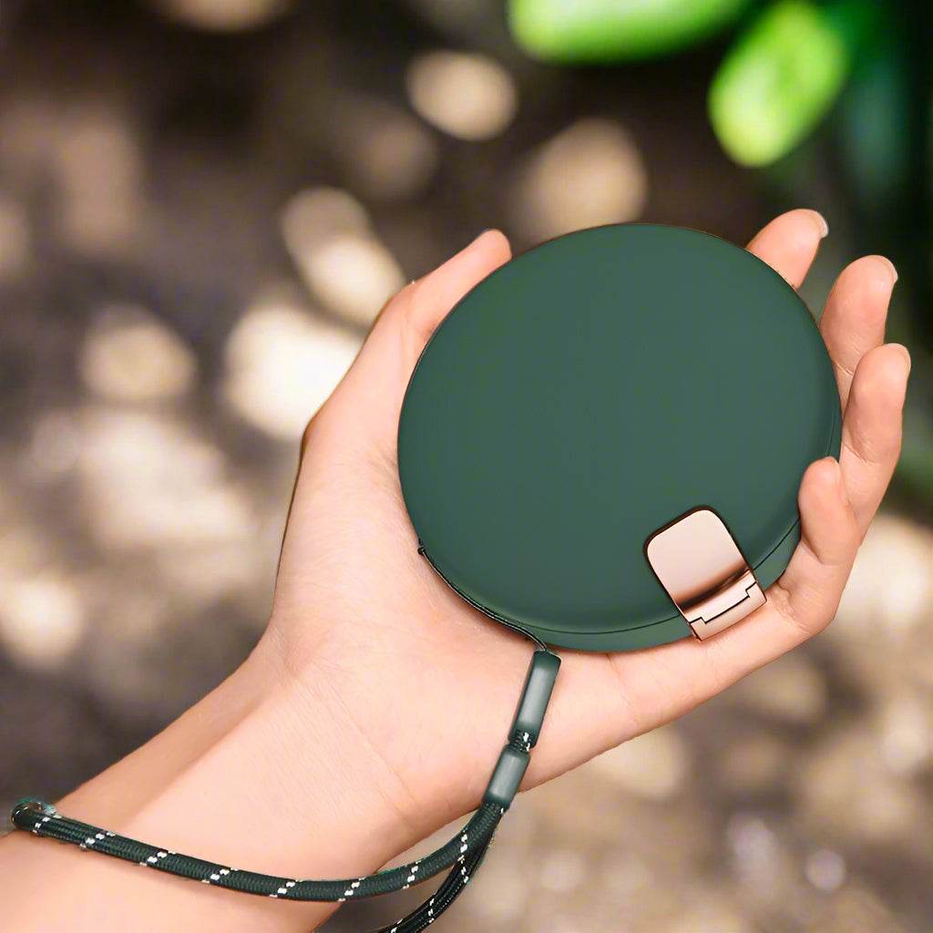 Multifunctional LUMi hand warmer with cosmetic mirror and powerbank in a sleek green design.